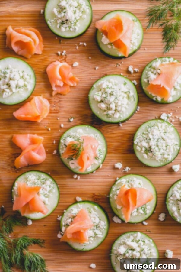 Assembling smoked salmon cucumber bites with feta and dill.