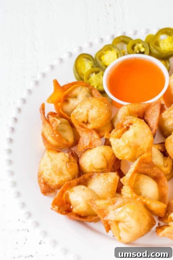 Super crispy wontons with smooth cream cheese filling with a kick. Homemade version of your favorite take-out appetizer with the same irresistibly delicious and addicting taste! Plus, a video tutorial on how to fold wontons 4 different ways.