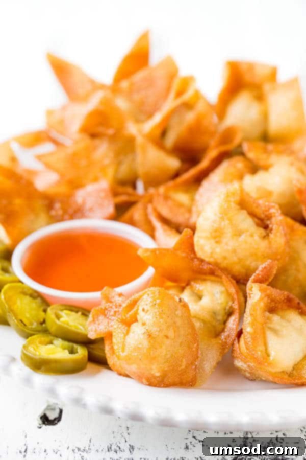 Super crispy wontons with smooth cream cheese filling with a kick. Homemade version of your favorite take-out appetizer with the same irresistibly delicious and addicting taste! Plus, a video tutorial on how to fold wontons 4 different ways.