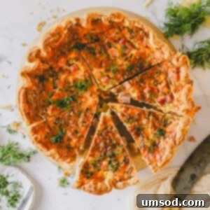 A golden-brown ham and cheese quiche, beautifully sliced into individual portions, resting on a rustic serving board.