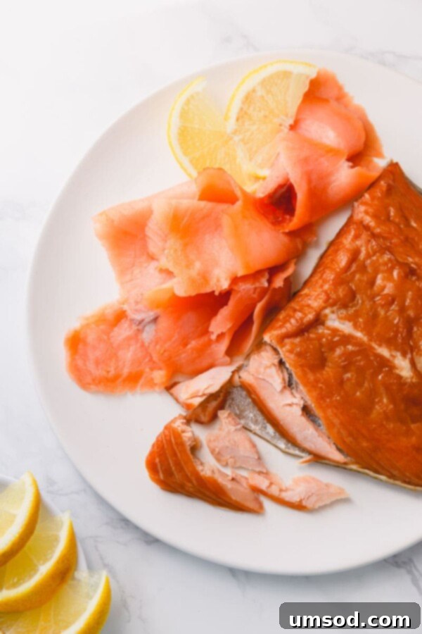 Cold vs Hot Smoked Salmon: A Deep Dive 2 A vibrant platter showcasing both hot-smoked and cold-smoked salmon varieties, elegantly garnished with fresh lemon slices, highlighting their distinct colors and textures.