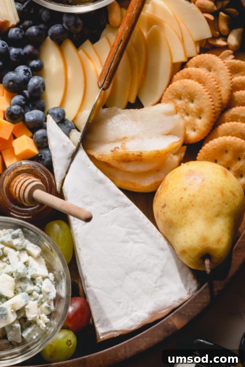 Crafting the Ultimate Charcuterie and Cheese Board 3 Carefully arranged cheese varieties with labels and individual serving knives on a elegant wooden board