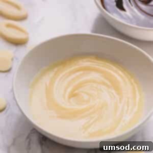 Glossy white chocolate ganache in a white bowl.