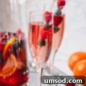 Sweet Summer Moscato Sangria 6 Moscato sangria in a champagne glass garnished with raspberries and blueberries.