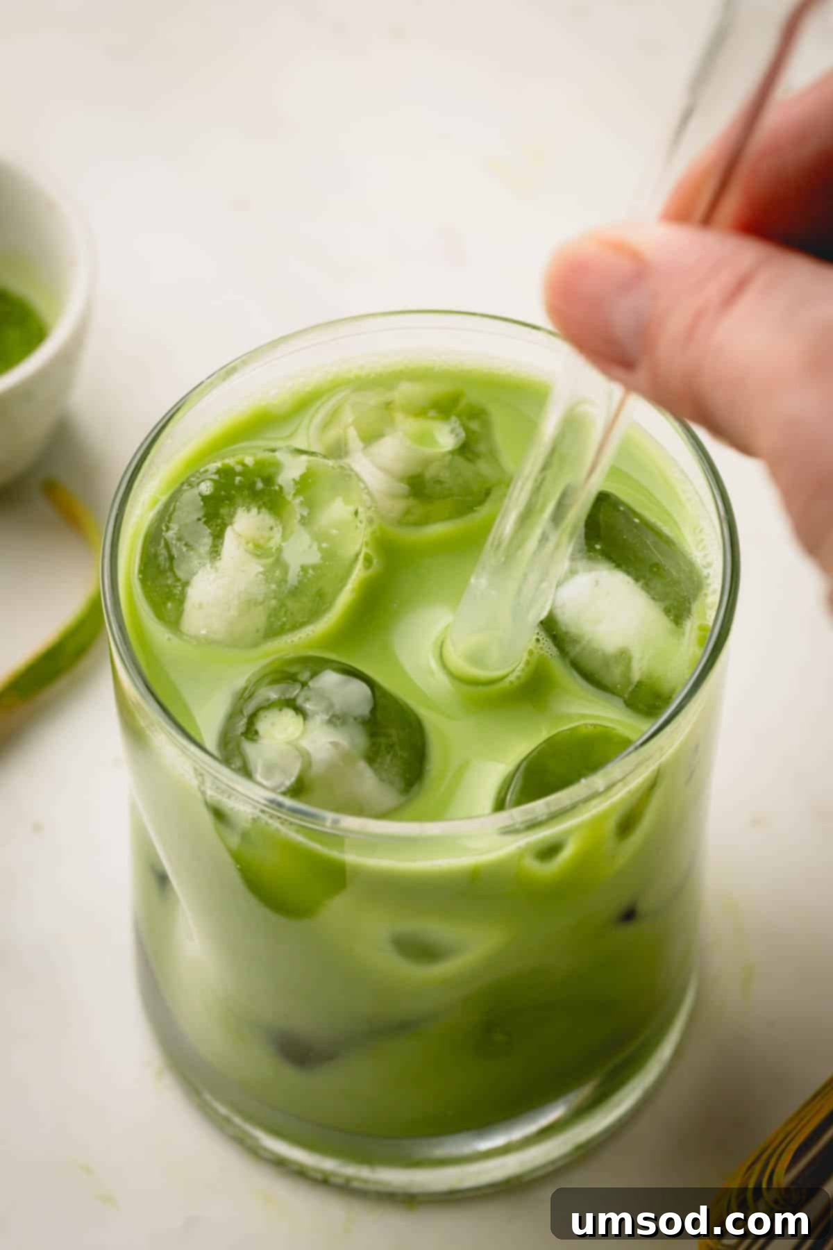 Mastering the Matcha Latte 12 A refreshing iced matcha latte served in a tall glass with a glass straw, ready to be enjoyed.