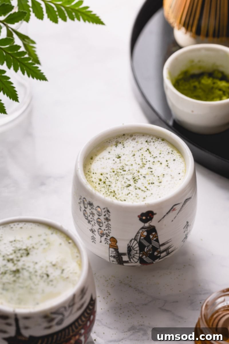 Mastering the Matcha Latte 13 Two perfectly prepared cups of matcha latte, accompanied by a small bowl of ceremonial grade matcha powder, inviting a serene moment.