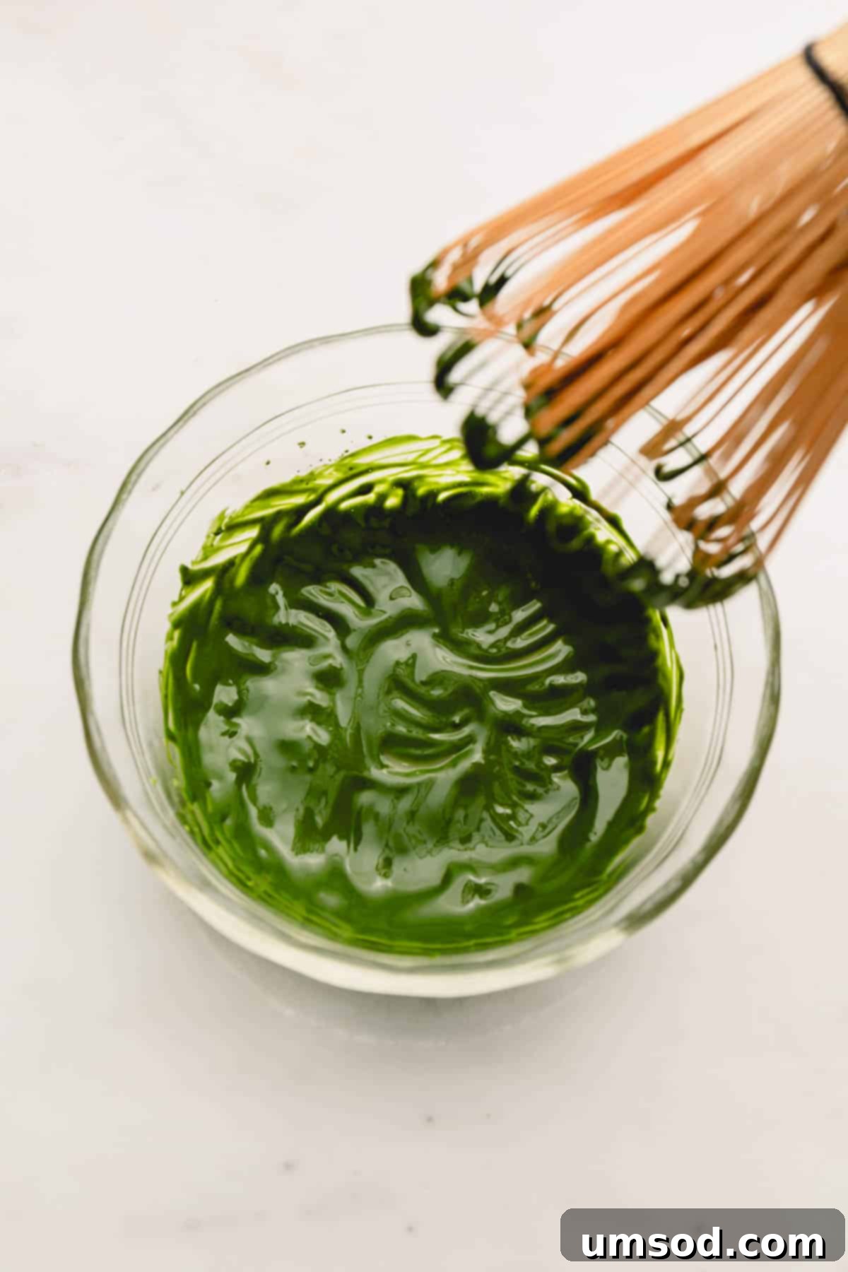 Mastering the Matcha Latte 7 A close-up of a perfectly smooth, vibrant green matcha paste in a glass bowl, showcasing its readiness for the next step.
