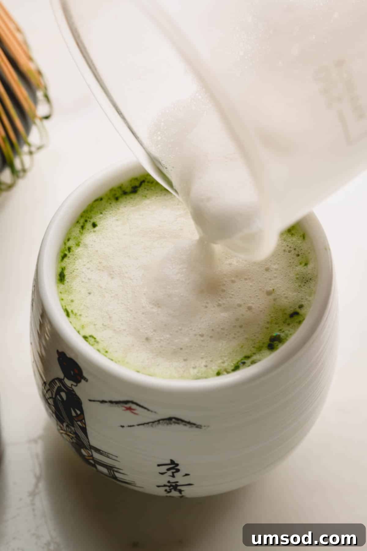 Mastering the Matcha Latte 10 A final touch: a spoonful of creamy milk foam is added to the top of a freshly made matcha latte, enhancing its luxurious texture.