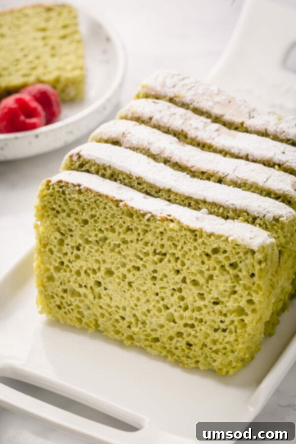 Matcha sponge cake served with fresh berries and a dusting of powdered sugar.