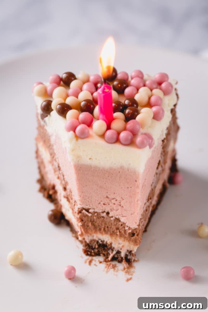 Beautifully decorated No-Bake Neapolitan Cheesecake topped with chocolate, strawberry, and white chocolate crispearls.