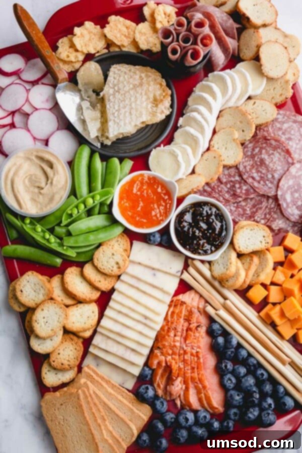 A vibrant spring charcuterie board featuring cheeses, cured meats, fresh fruits, and vegetables, beautifully arranged on a wooden platter.
