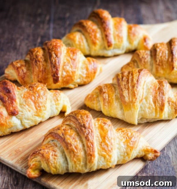 Flaky Homemade Croissants 11 Freshly baked homemade croissants with a rich golden color and visible flaky layers, perfectly arranged for a delectable treat.