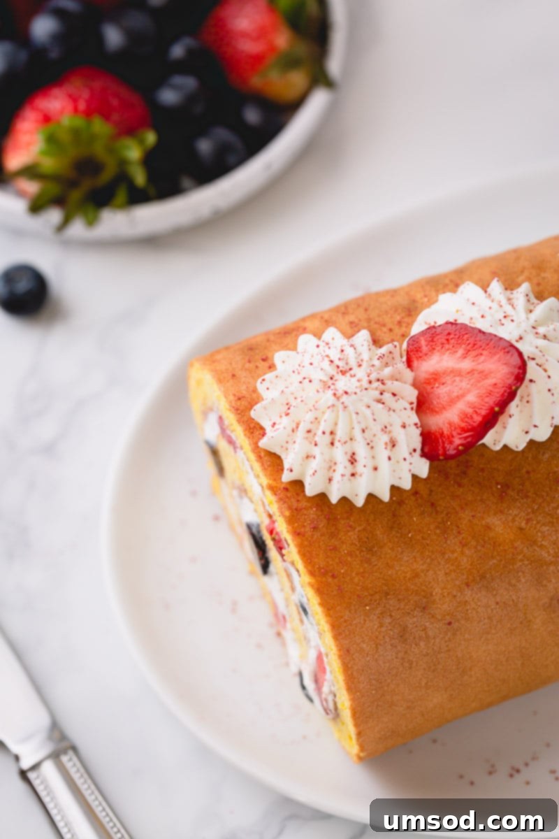 The finished Berrylicious Roll Cake, beautifully sliced to reveal its perfect spiral and crack-free texture, ready to be presented and enjoyed.