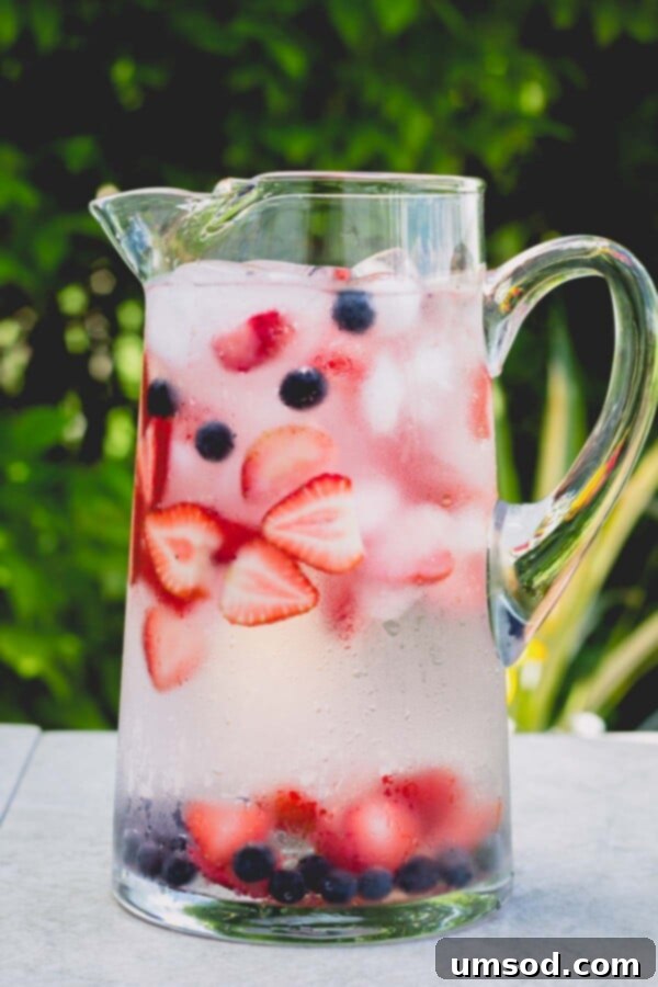 Three Ways to Refresh with Infused Water 4 Glass jar filled with water and an assortment of fresh red and blue berries.