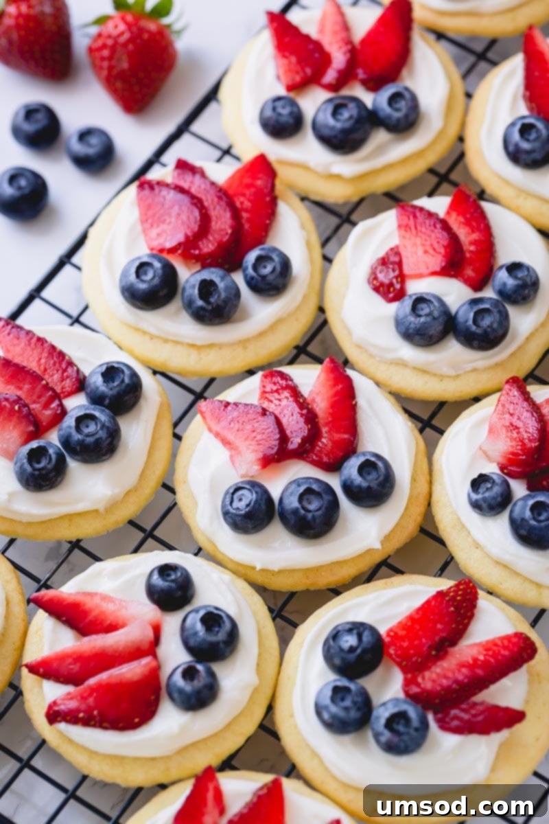 Delicious mini fruit pizza with white chocolate cream cheese frosting, showcasing vibrant fresh fruits – an ideal summer party dessert.