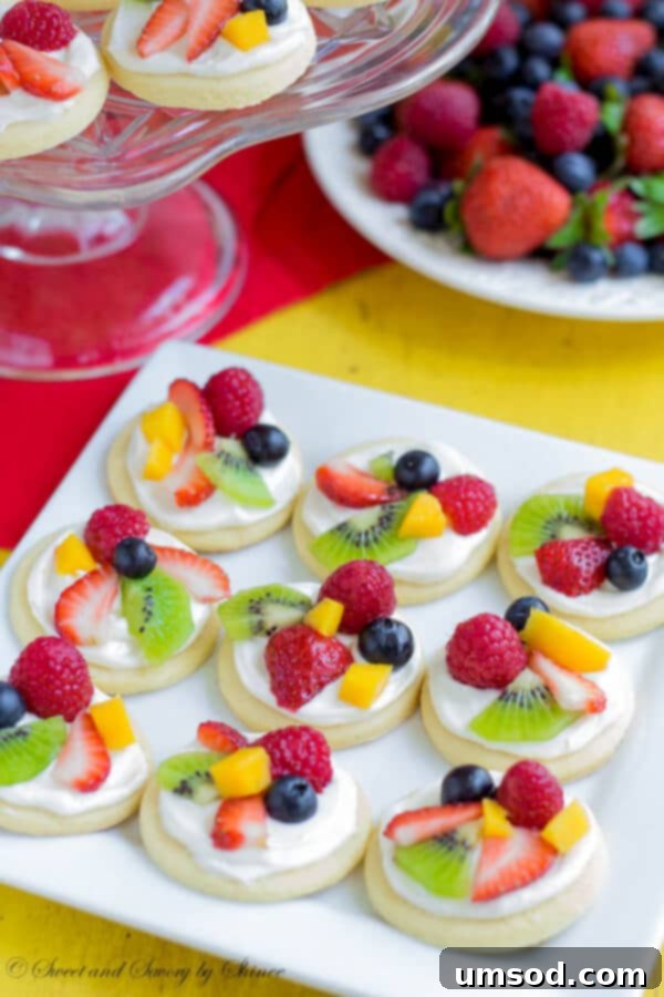 An earlier image of the summer classic, mini fruit pizzas, featuring soft sugar cookies, white chocolate cream cheese filling, and an abundance of fresh, colorful fruits.