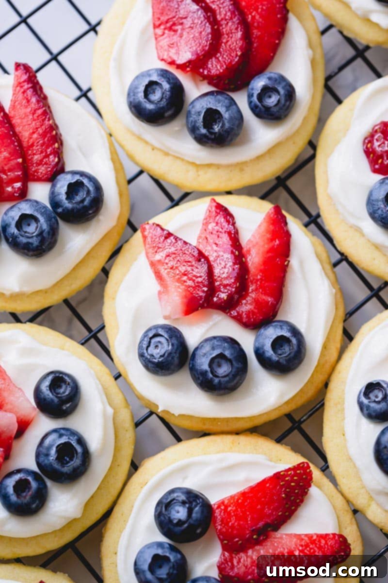 A stunning spread of mini fruit pizzas, garnished with an assortment of colorful fresh berries and fruits, ready for a party.
