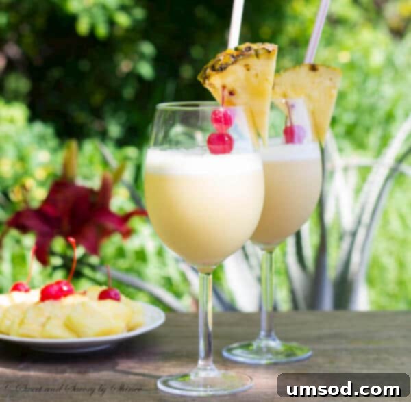 Close-up of a perfectly blended Pina Colada with orange juice, showcasing its creamy texture