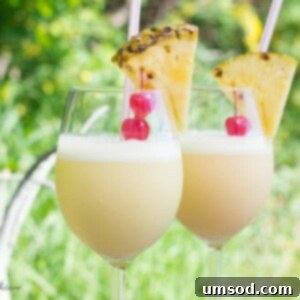 Pina Colada with orange juice, garnished with pineapple