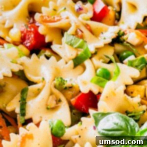 A bowl of vibrant veggie pasta salad with farfalle pasta, bell peppers, broccoli, and a balsamic dressing.