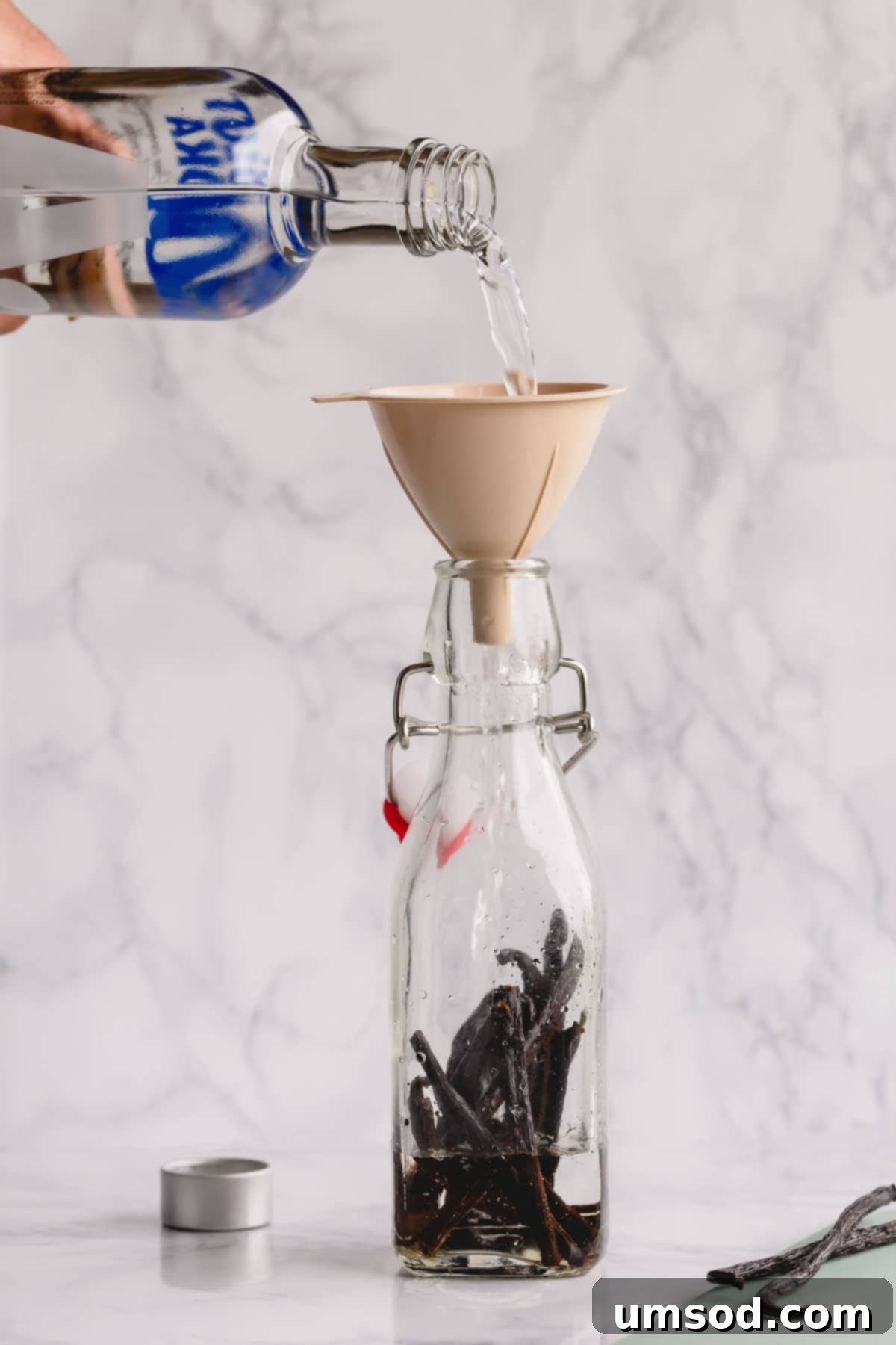 Crafting Your Own Vanilla Extract 5 Pouring vodka into a bottle filled with sliced vanilla beans.