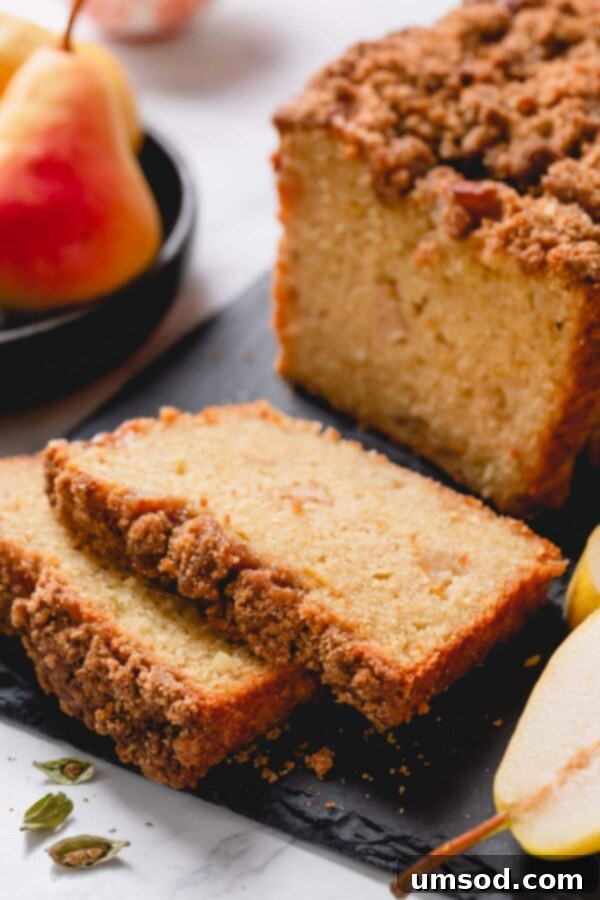 A stack of golden-brown caramelized pear quick bread slices, arranged neatly on a dark cutting board, inviting a taste.