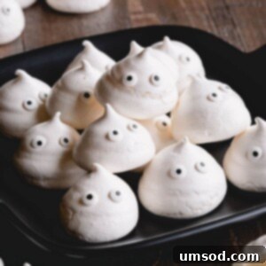 Ghostly Meringue Delights 8 Close-up of a meringue ghost cookie with a happy expression and orange bow tie