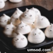 Ghostly Meringue Delights 9 A ghostly meringue cookie with a smiling face.