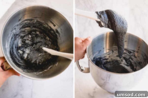 Macaron batter being folded with a silicone spatula, showing its lava-like consistency.