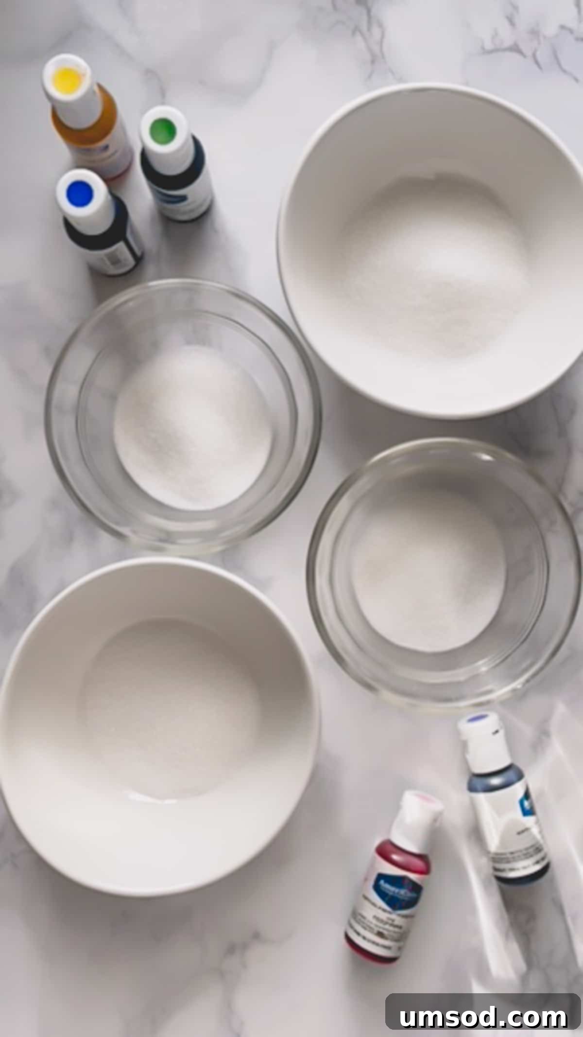 Bowls of granulated sugar and various gel food colorings, the essential ingredients.