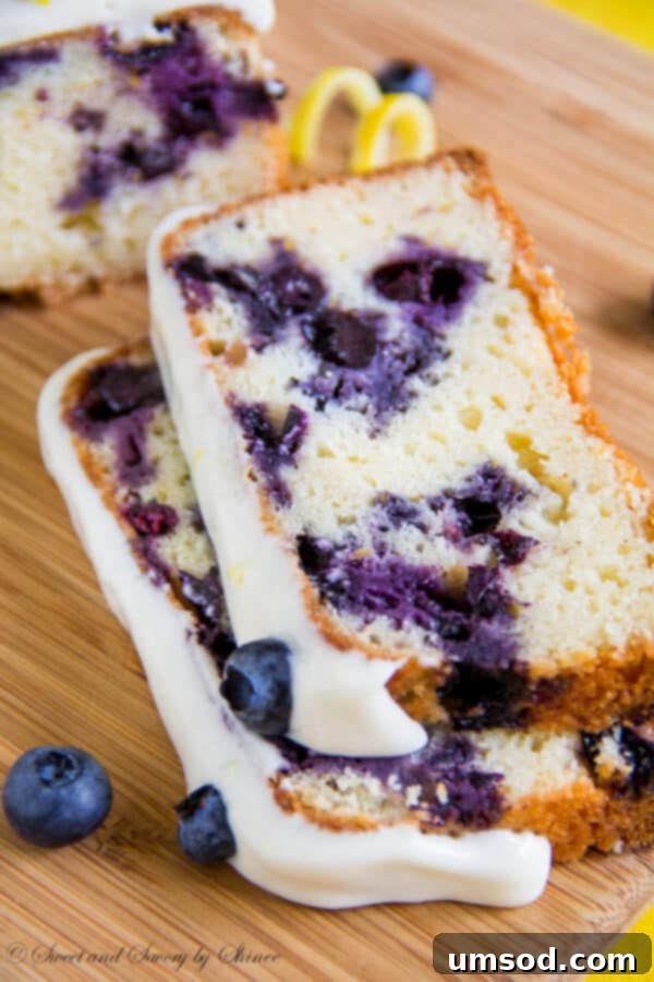 Zesty Lemon Blueberry Bake 3 A close-up view of a perfectly baked blueberry lemon cake, showcasing its moist crumb, evenly distributed fresh blueberries, and the rich, creamy texture of the lemon cream cheese frosting.