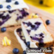 Zesty Lemon Blueberry Bake 8 A final close-up image of the blueberry lemon cake, emphasizing its fluffy texture, vibrant blueberries, and the tempting, smooth lemon cream cheese glaze, perfectly ready to be served and enjoyed.