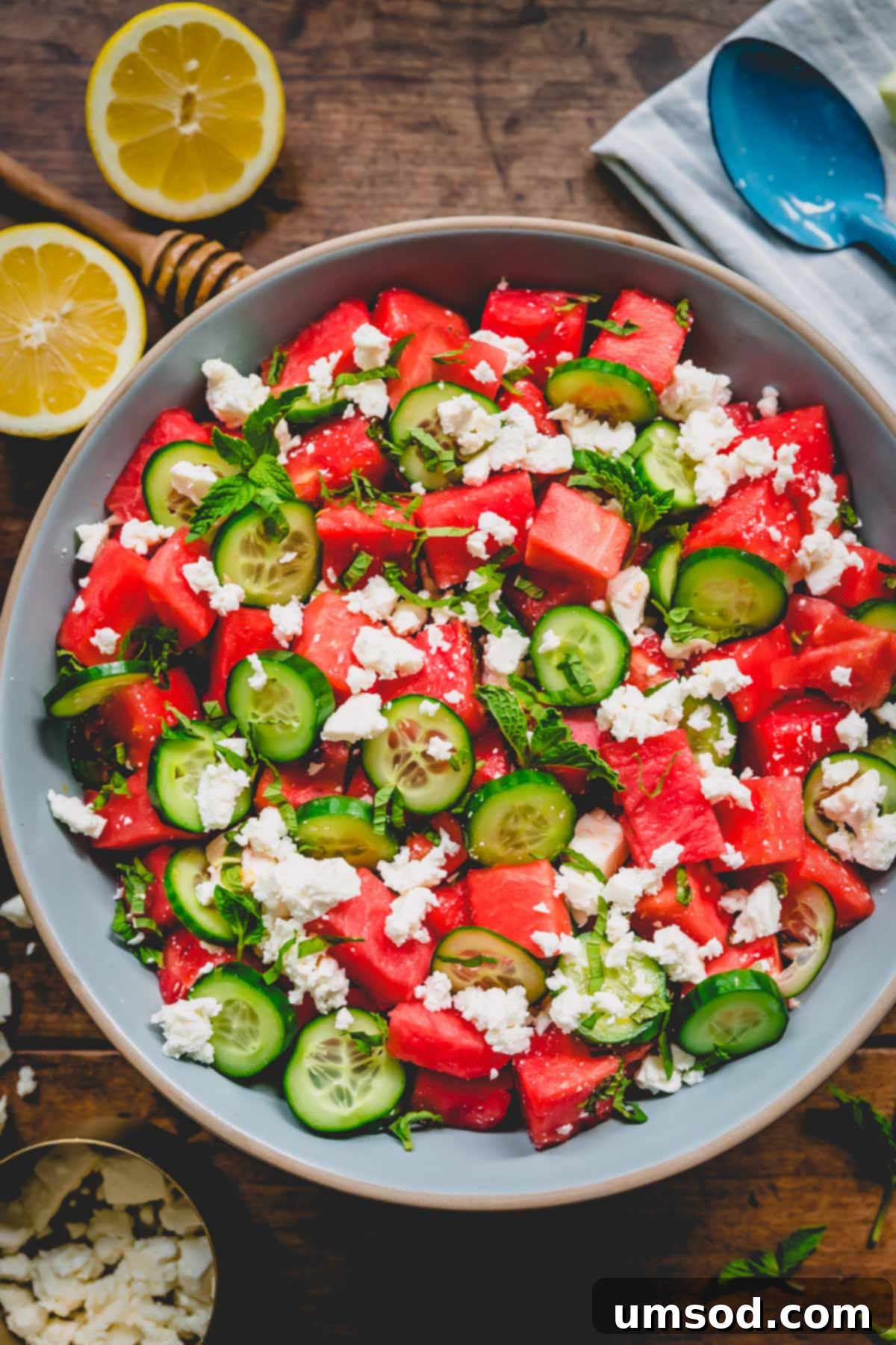 A large serving plate filled with refreshing watermelon feta salad, garnished with fresh mint.