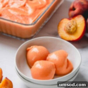 Golden Peach Dream 6 Three scoops of peach ice cream in a white bowl, ready to be served.