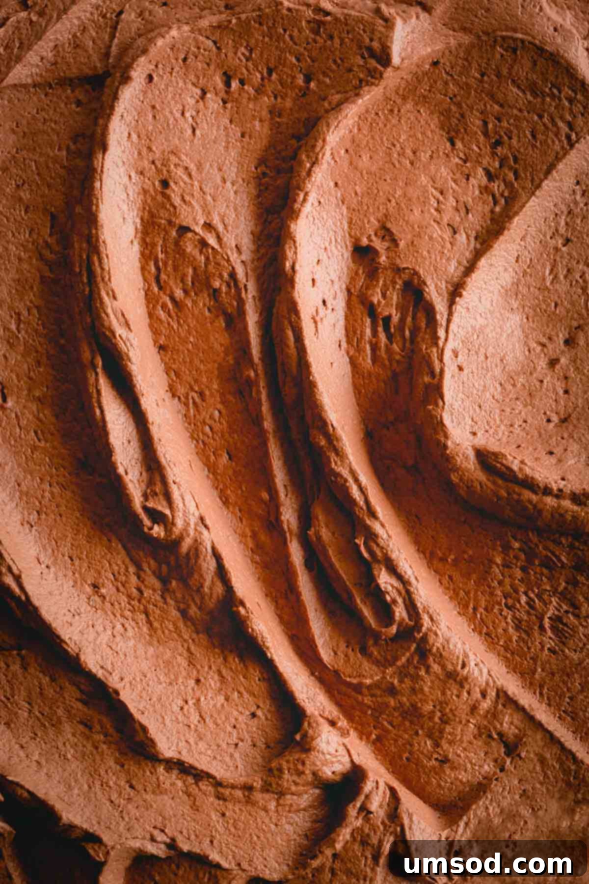 Decadent Chocolate Mousse 7 Close-up of the rich, airy, and glossy chocolate mousse frosting in a bowl, showcasing its perfect texture.