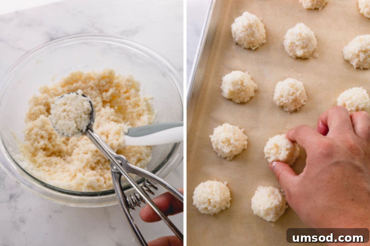 Freshly baked coconut macaroons arranged in neat rows on a parchment-lined baking sheet, displaying their golden brown edges and perfectly formed shapes.