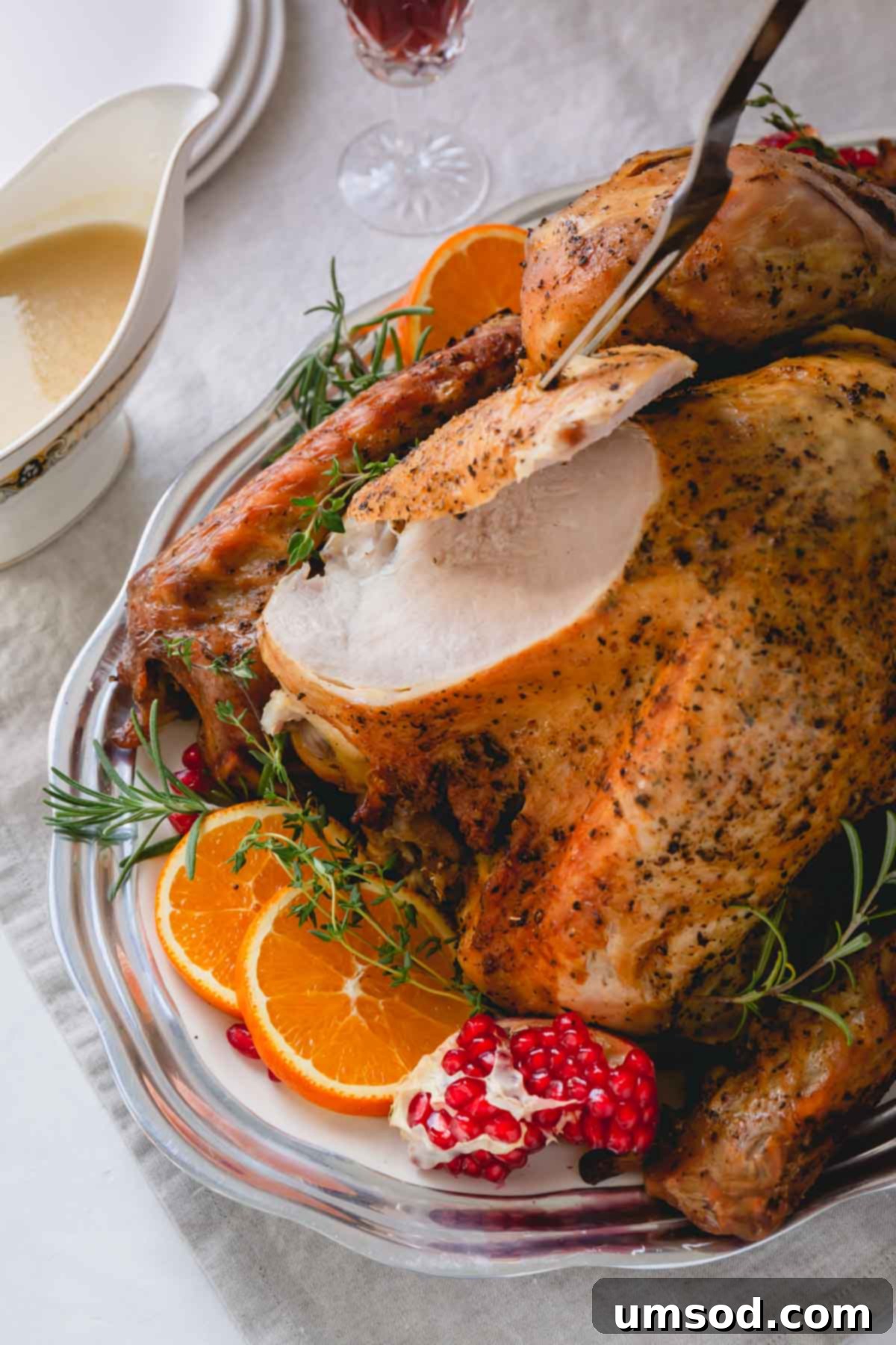 Whole roasted turkey on a platter with a beautifully sliced breast.