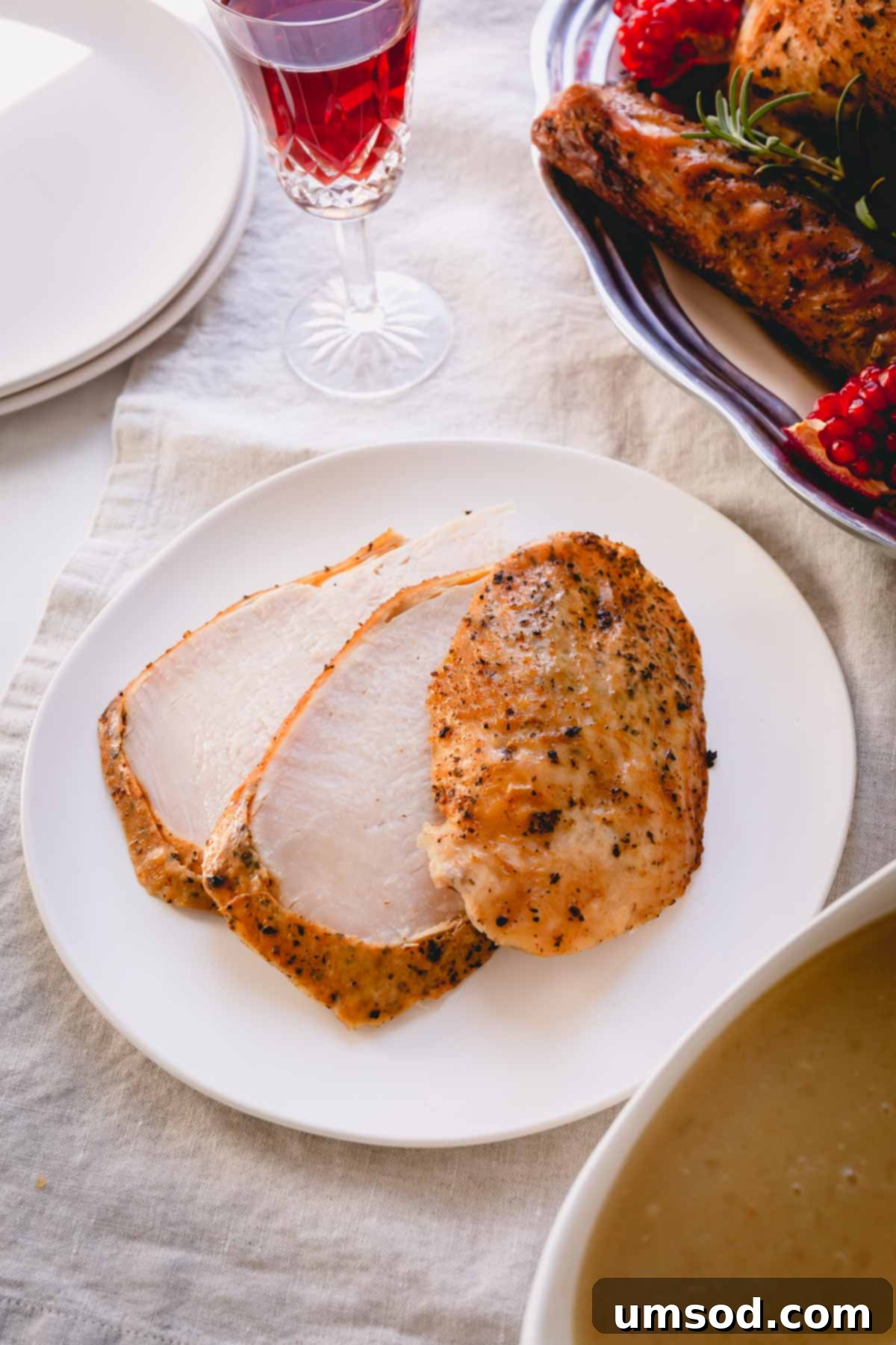 Three succulent sliced turkey breast pieces arranged on a small white plate.