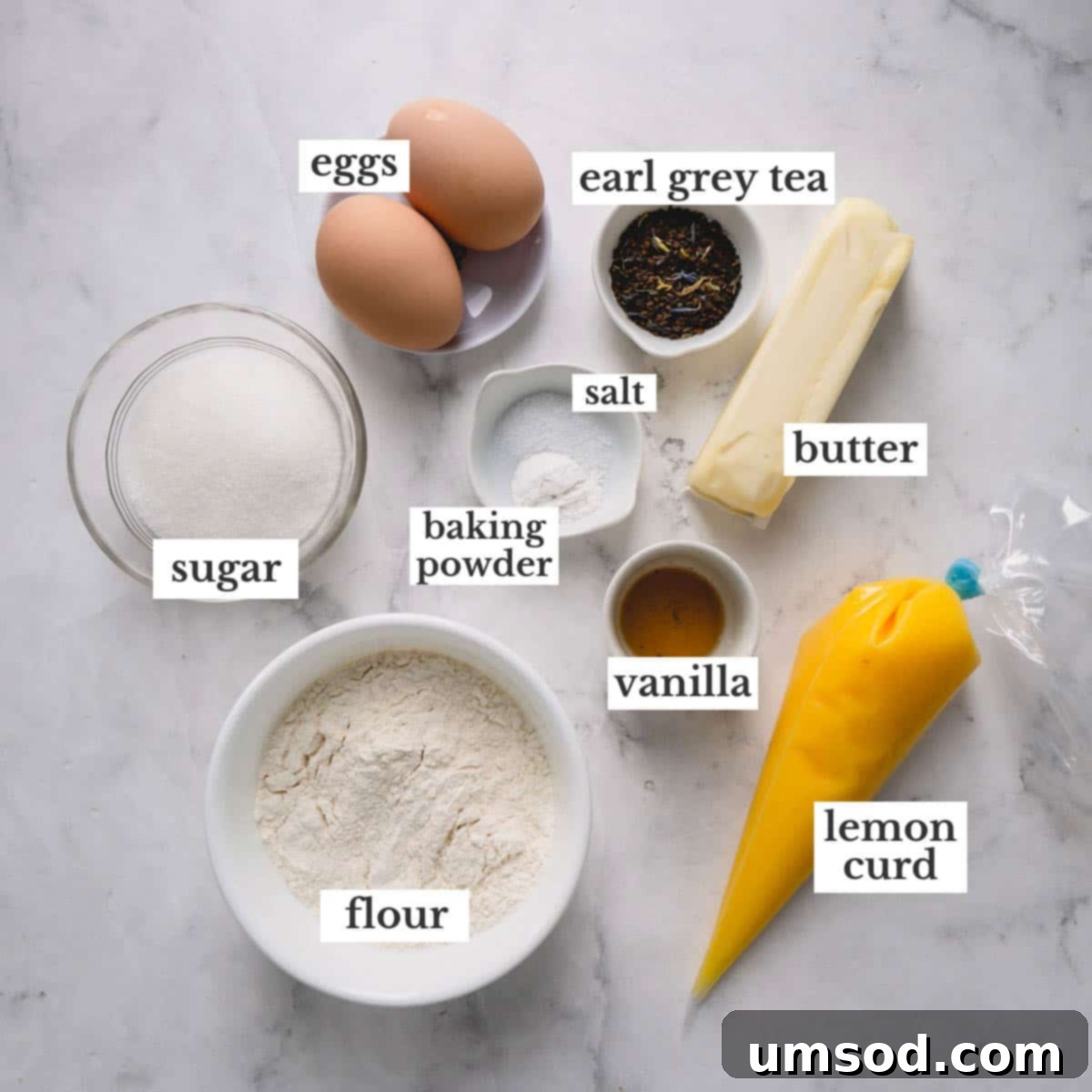 Zesty Bergamot Madeleines 4 A flat lay photograph displaying all the fresh, high-quality ingredients needed for baking delightful Earl Grey Madeleines with lemon curd, neatly arranged on a rustic wooden surface.