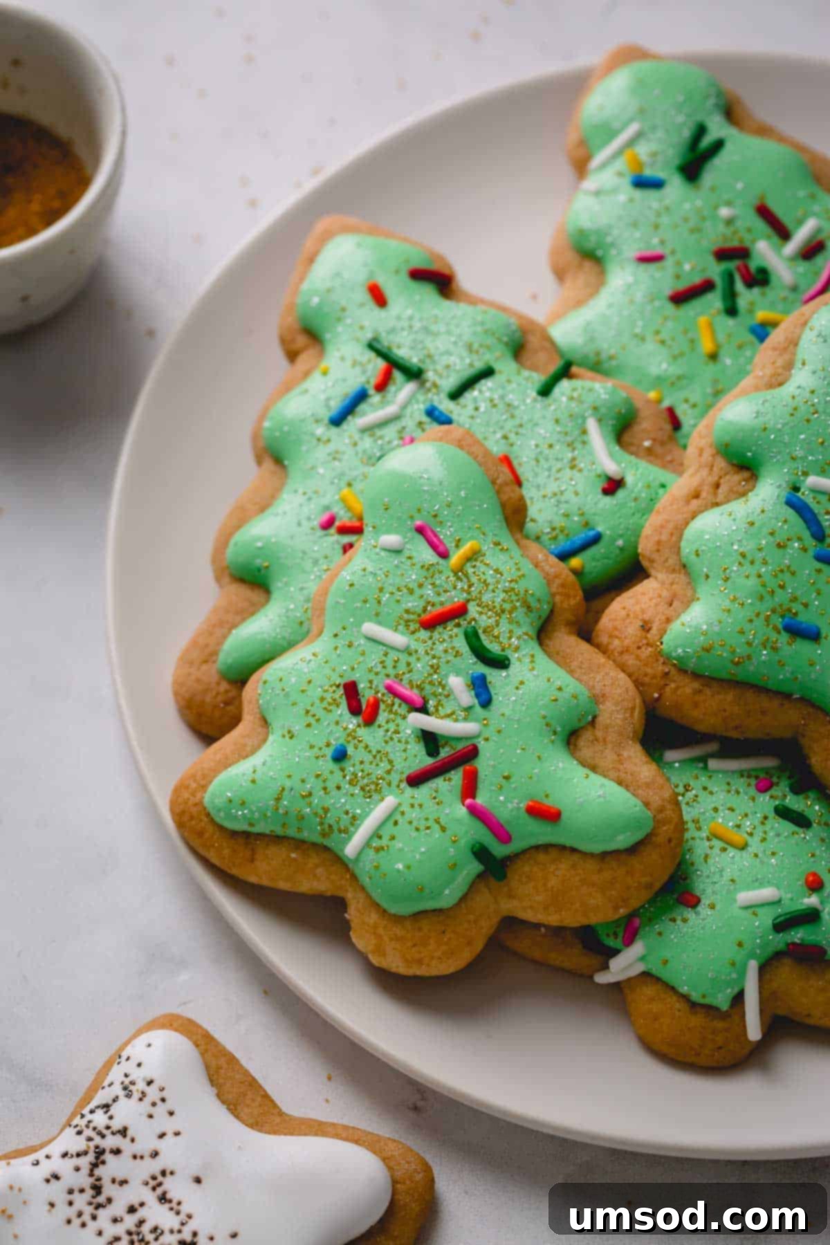A festive plate of honey cookies, beautifully decorated like Christmas trees, ready for holiday gifting or a delightful gathering.