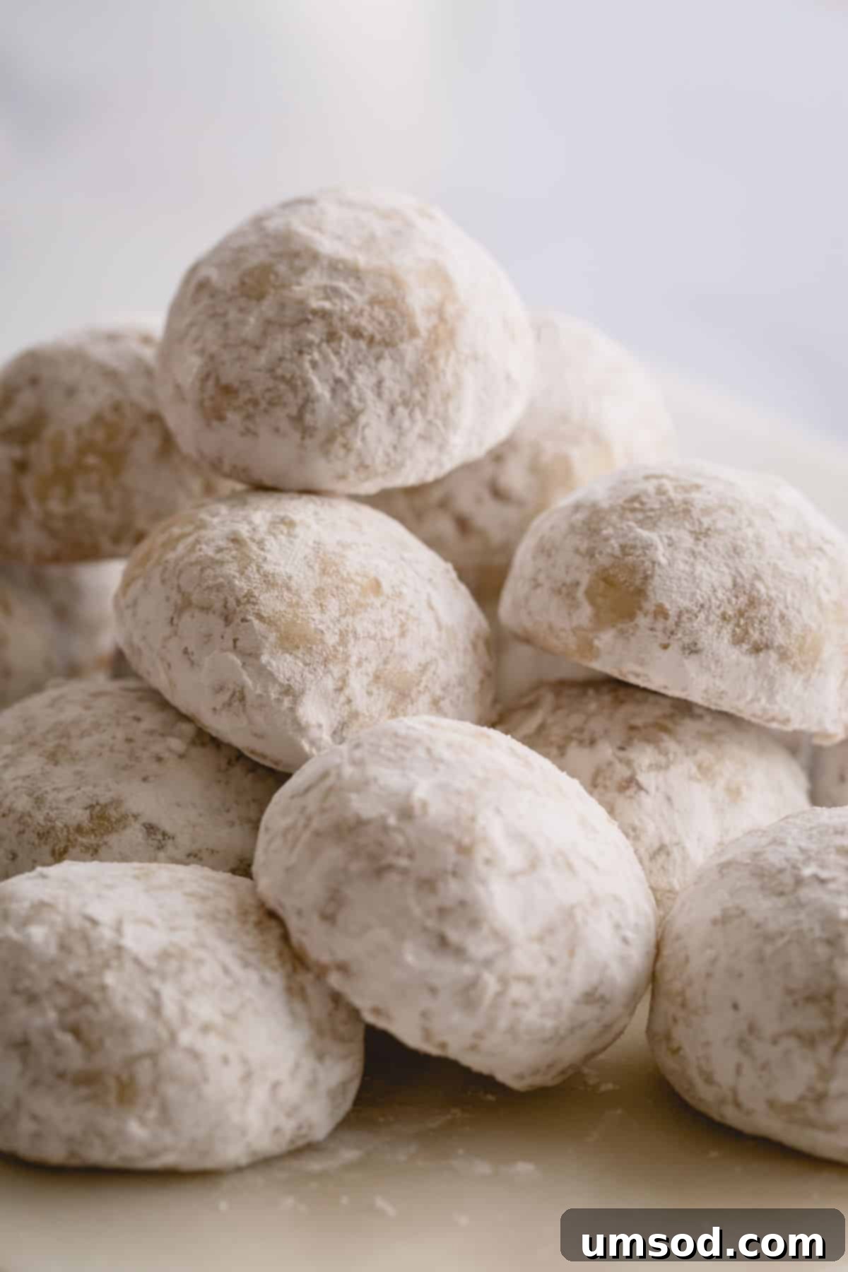 A charming stack of perfectly baked and double-coated snowball cookies, ready to be enjoyed or shared.