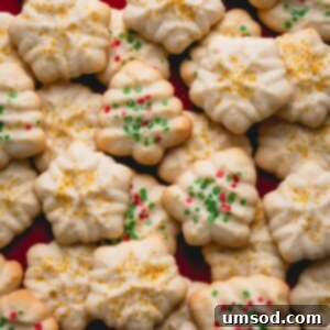 A stack of beautifully crafted holiday-shaped almond spritz cookies.