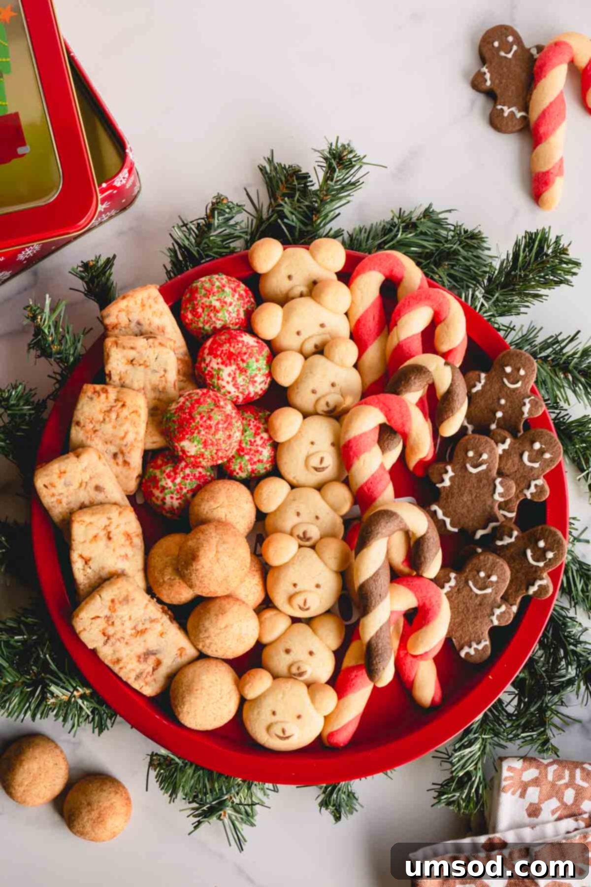 Tek Hamurdan 6dan Fazla Lezzet: Efsanevi Tereyağlı Kurabiye Hamuru 2 A beautifully arranged round platter showcasing six distinct varieties of homemade Christmas butter cookies, perfect for holiday gatherings.