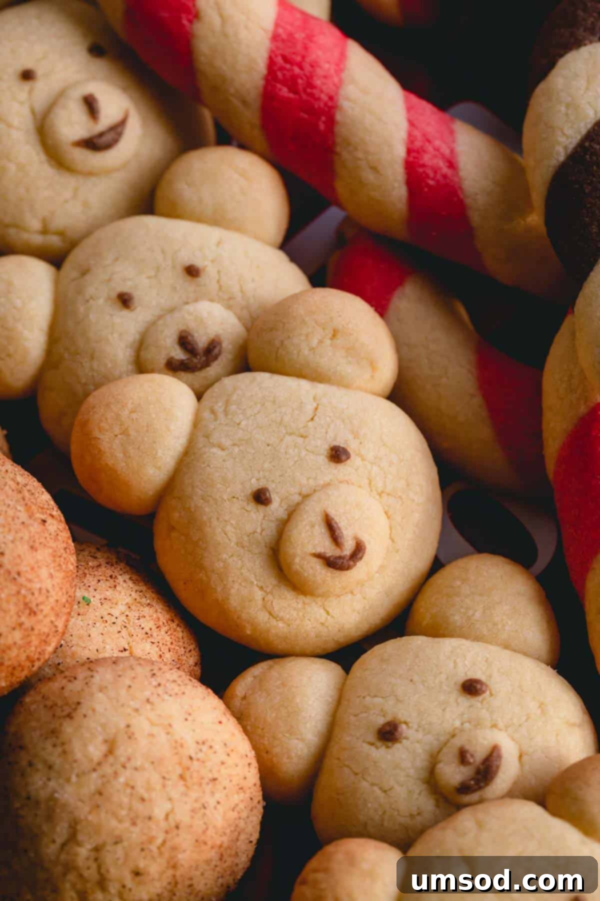 Tek Hamurdan 6dan Fazla Lezzet: Efsanevi Tereyağlı Kurabiye Hamuru 13 A charming platter filled with baked teddy bear butter cookies, many featuring piped chocolate eyes and mouths for a delightful finish.