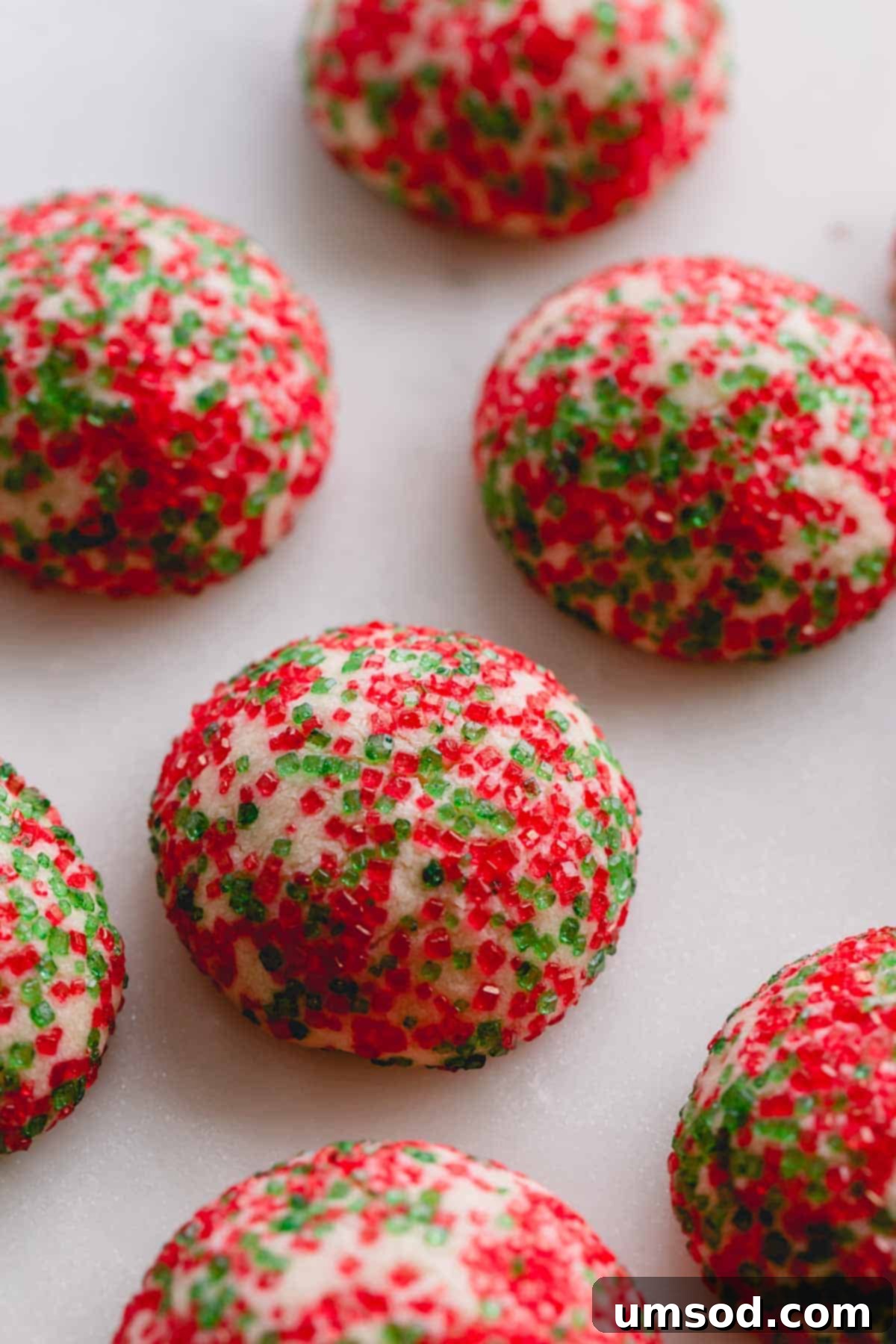 Tek Hamurdan 6dan Fazla Lezzet: Efsanevi Tereyağlı Kurabiye Hamuru 19 A collection of freshly baked red and green sugar-coated butter cookies, showcasing their vibrant holiday colors.