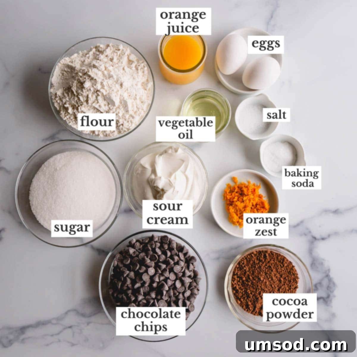 Zesty Orange Chocolate Muffins 4 A flat lay photograph displaying all the fresh and dry ingredients meticulously arranged for making chocolate orange muffins.