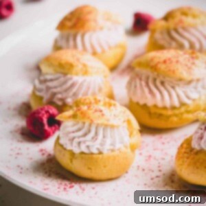 Romantic Valentine's Day Sweets Beyond Chocolate 6 Mini raspberry cream puffs on a white platter dusted with freeze-dried raspberry powder.