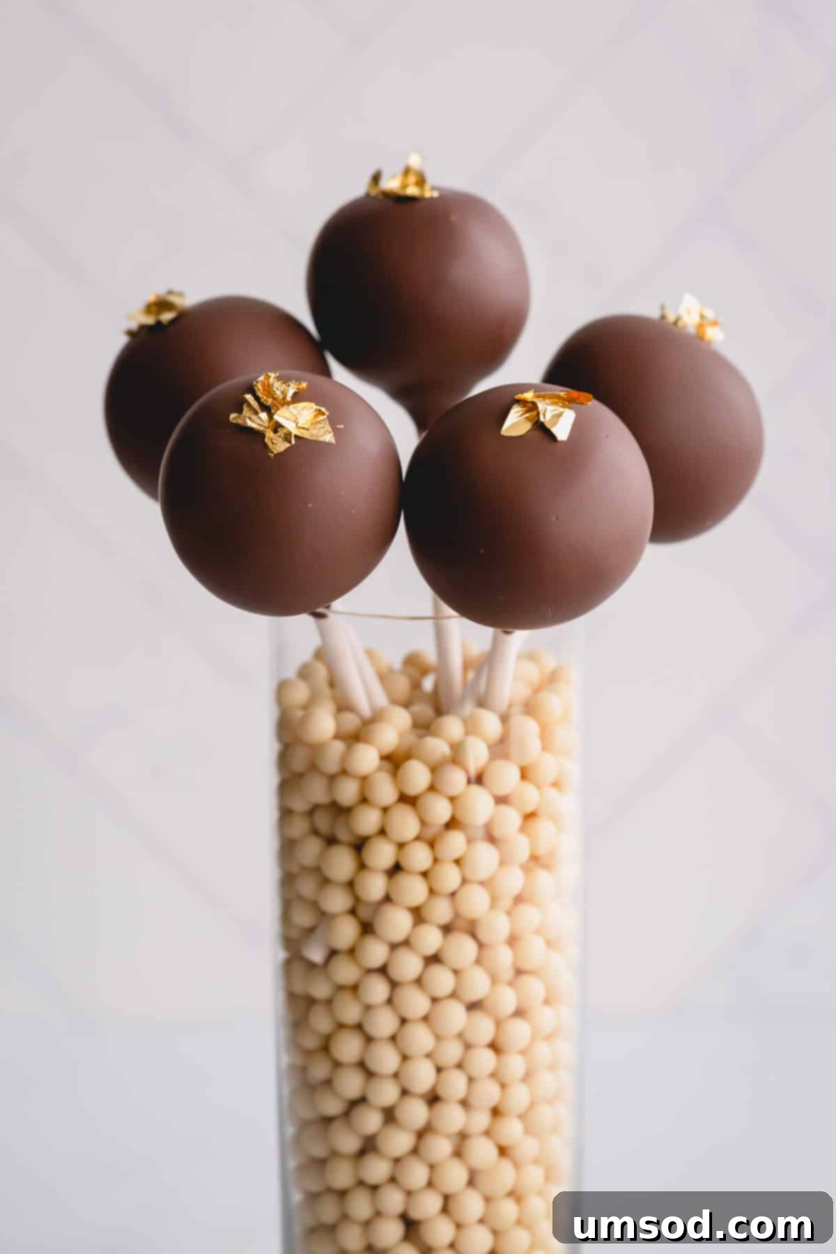 chocolate cake pops in a jar of decorative sugar pearls, ready for a party.