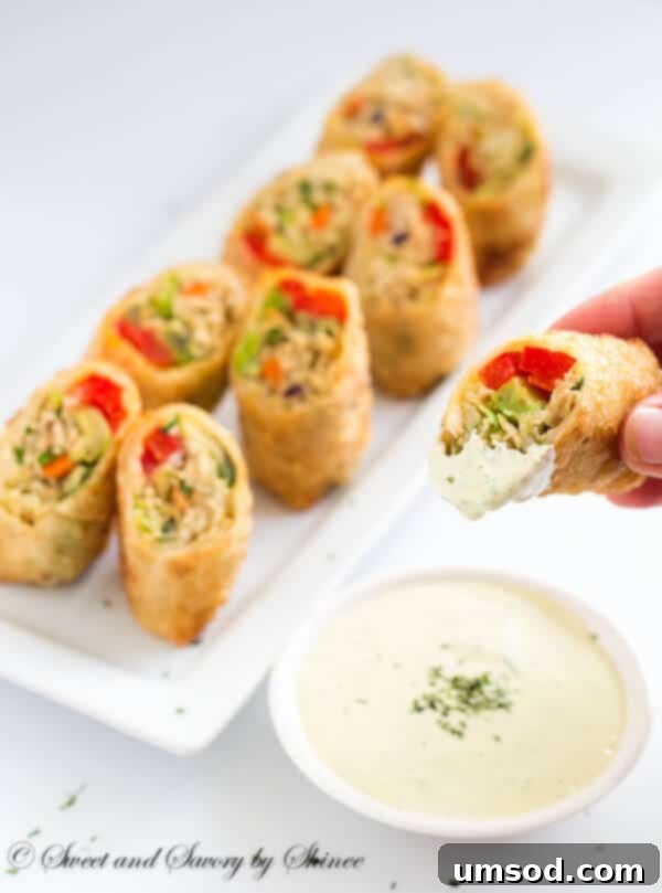 Assortment of ingredients for chicken avocado egg rolls filling: shredded chicken, cabbage, avocado slices, and red pepper.
