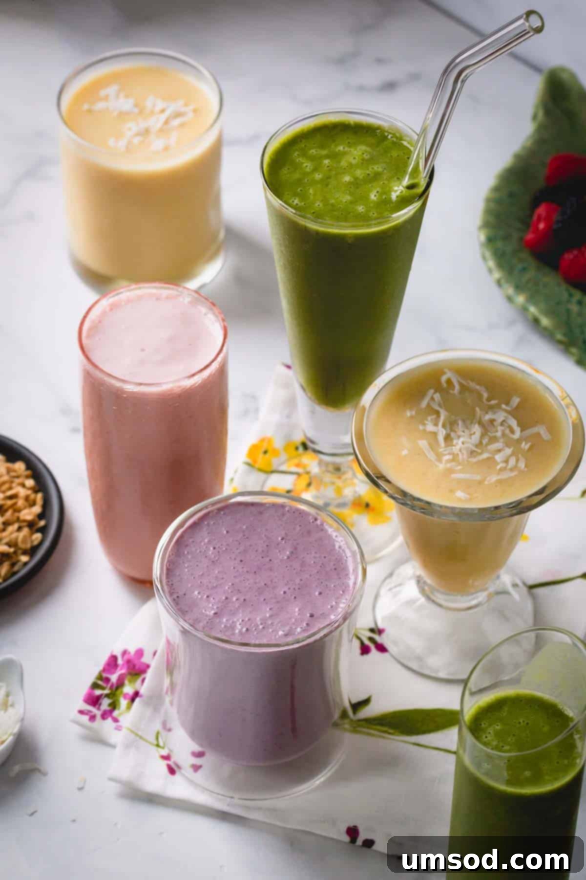 An array of different kinds of smoothies, showcasing various colors and textures in glasses.